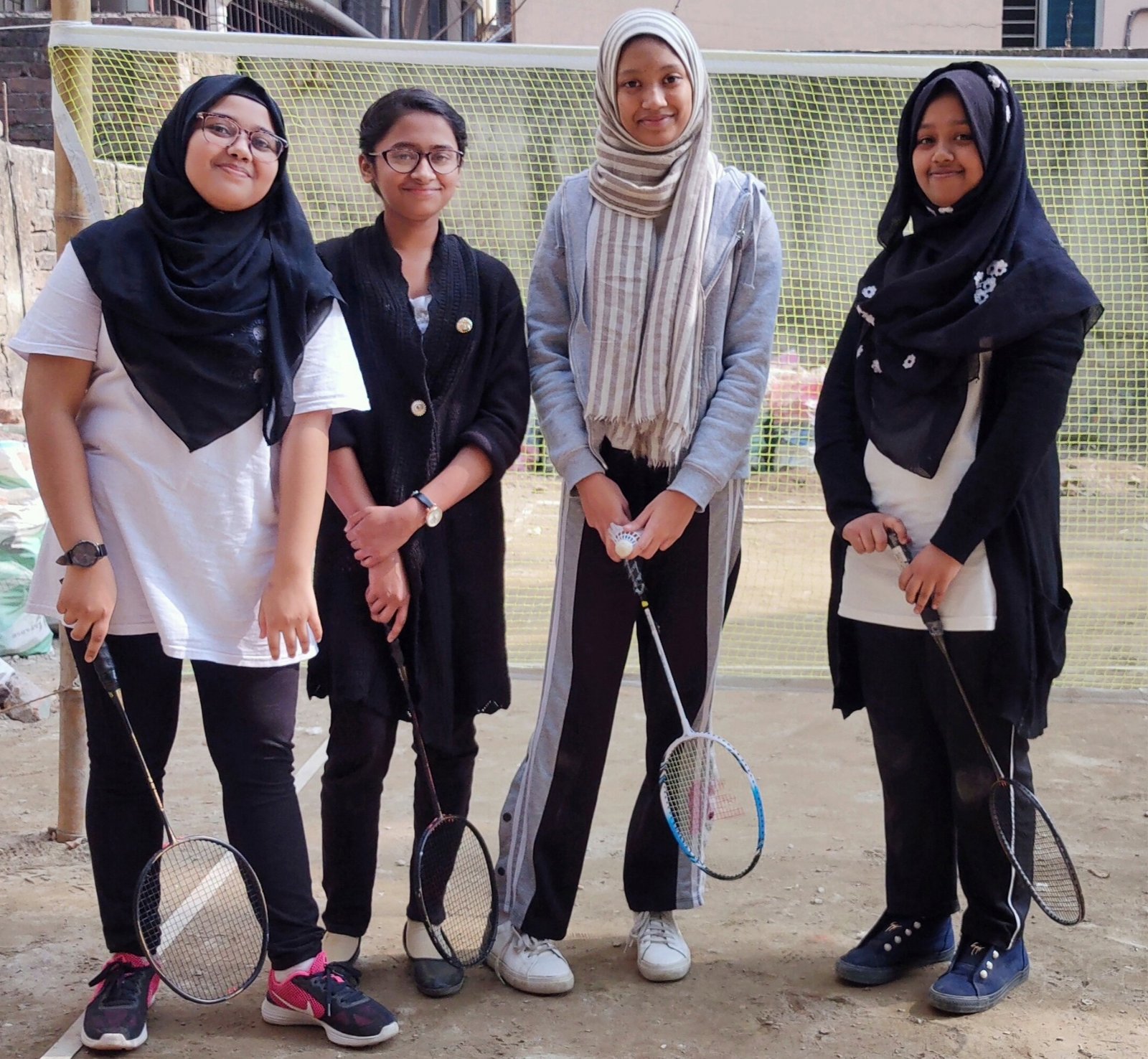 A group of students from Juvenile English Medium School posing with badminton rackets, representing the school's commitment to sports and extracurricular activities